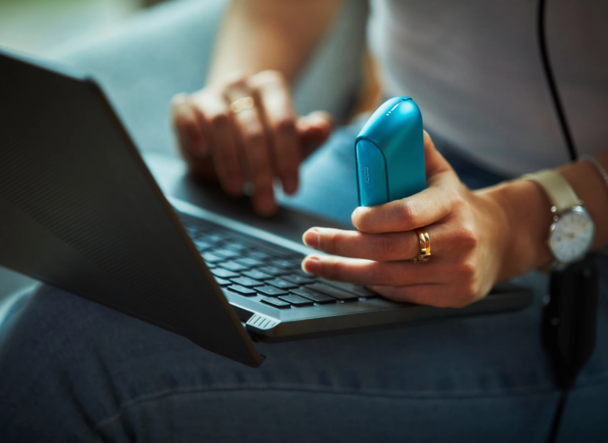 Osoba vykonáva online diagnostiku na modrej vreckovej nabíjačke IQOS ILUMA